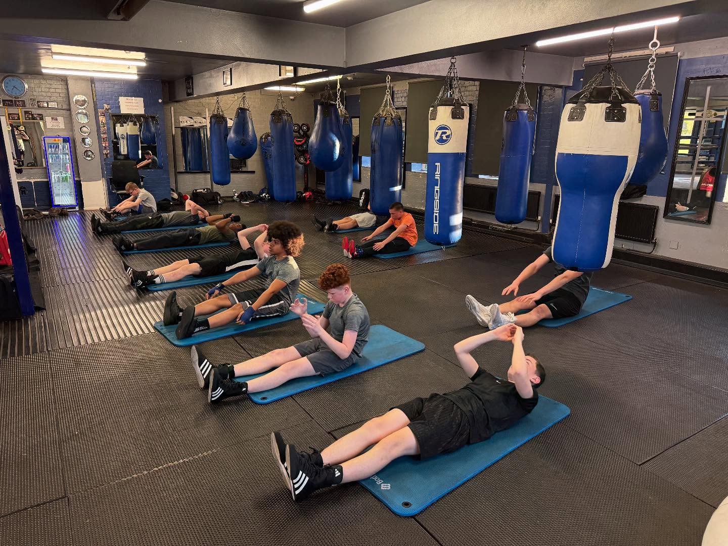 Young boxers doing core exercises in the gym